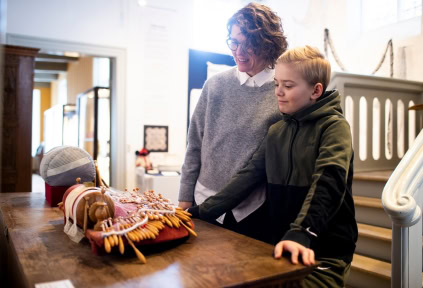A woman and a young boy are looking at lace