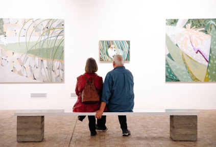 Ein Ehepaar sitzt auf einer Bank und betrachtet der Kunst im Kunstmuseum Tondern