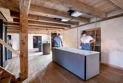 Eine junge Frau und ein Mann betrachten die Ausstellung in der Mühle von Højer