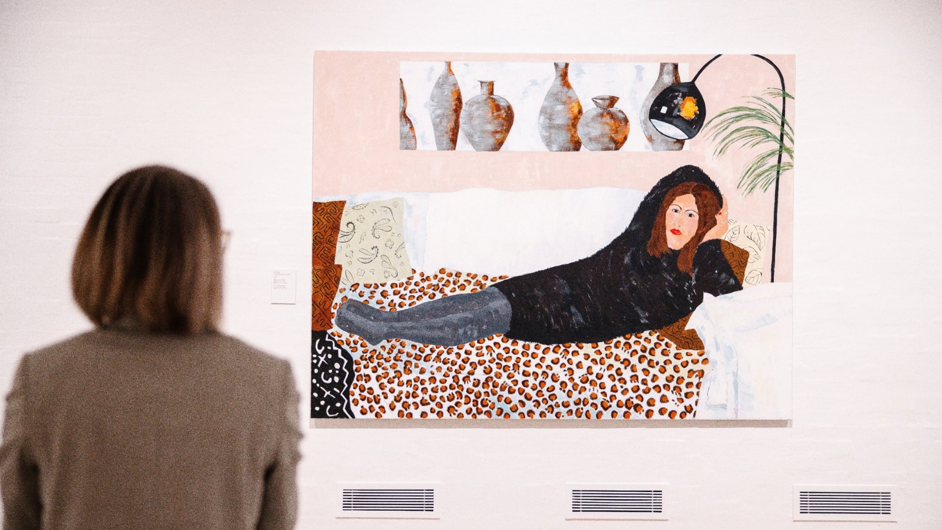A woman is looking at an artwork by Anette Abrahamsson