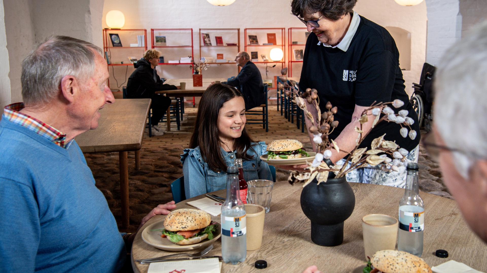 Pige får serveret en sandwich i caféen på Sønderborg Slot.