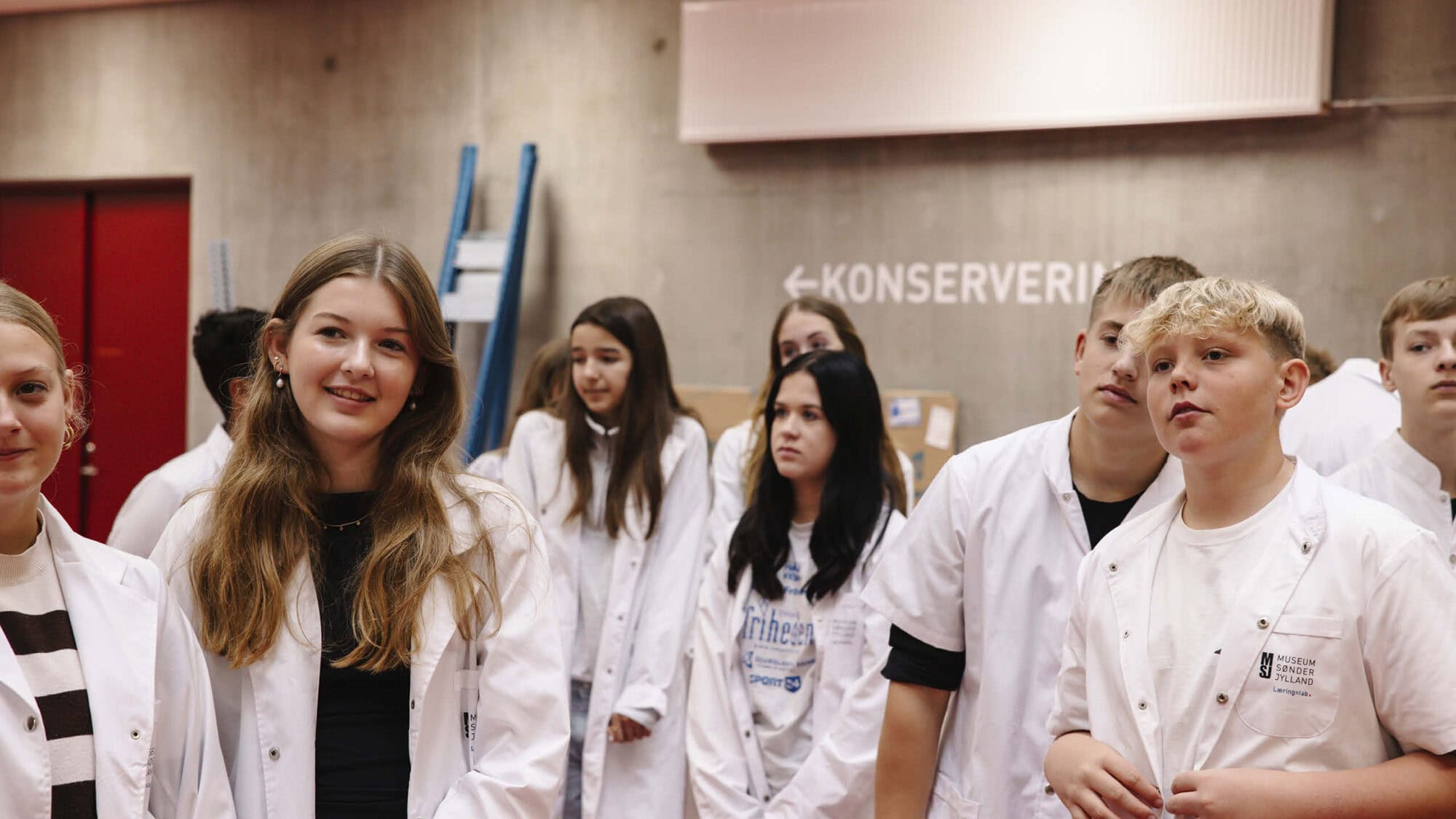 En gruppe unge mennesker står i hvide kitler i bevaringscenter sønderjylland
