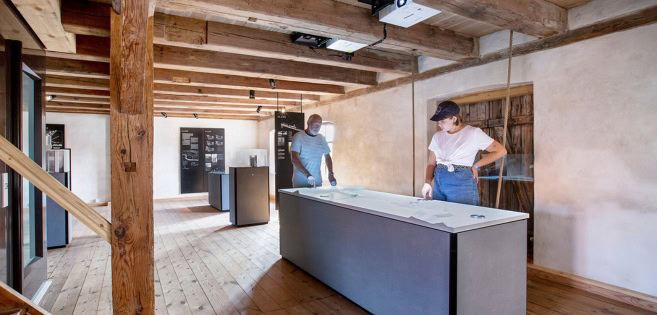 Two visitors explore the exhibition at Højer Mill.
