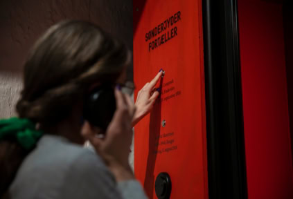 Eine Frau hört sich in der Ausstellung im Schloss Sonderburg eine Geschichte an
