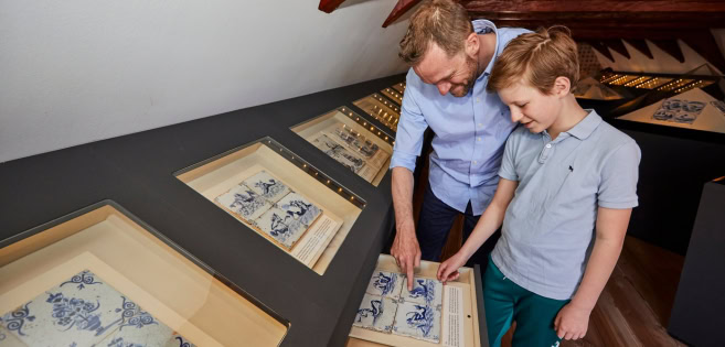 Ein Mann und ein Junge betrachten die holländischen Fliesen im Museum für Kulturgeschichte in Tondern.