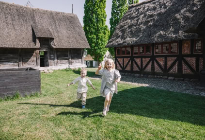 Two children are running around the Open-Air Museum in Haderslev