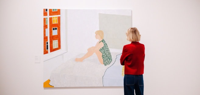 Eine junge Frau betrachtet die Kunstwerke von Anette Abrahamsson im Kunstmuseum Tondern.