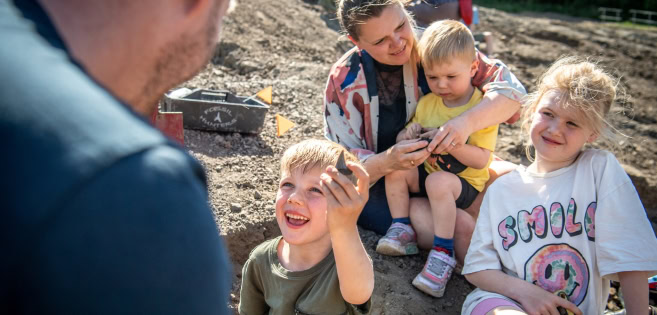 In the clay pit at Gram, a family examines a fossil they found
