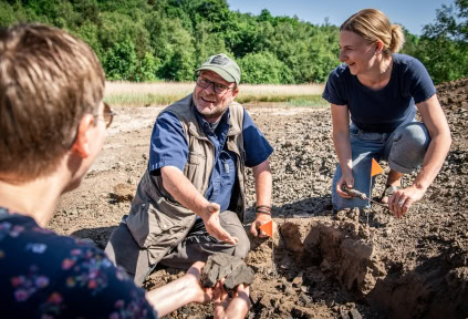 A man and two women are in Gram Clay Pit searching for fossils