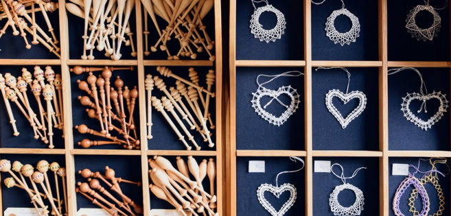 Kleine Klöppelspitzen und traditionelles Klöppelwerkzeug.