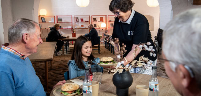 Im Schloss-Café wird einer Familie das Essen serviert.
