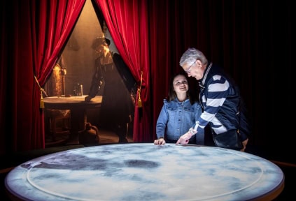 An elderly woman and a girl are exploring the digital installation in the exhibition about King Christian II at Sønderborg Castle
