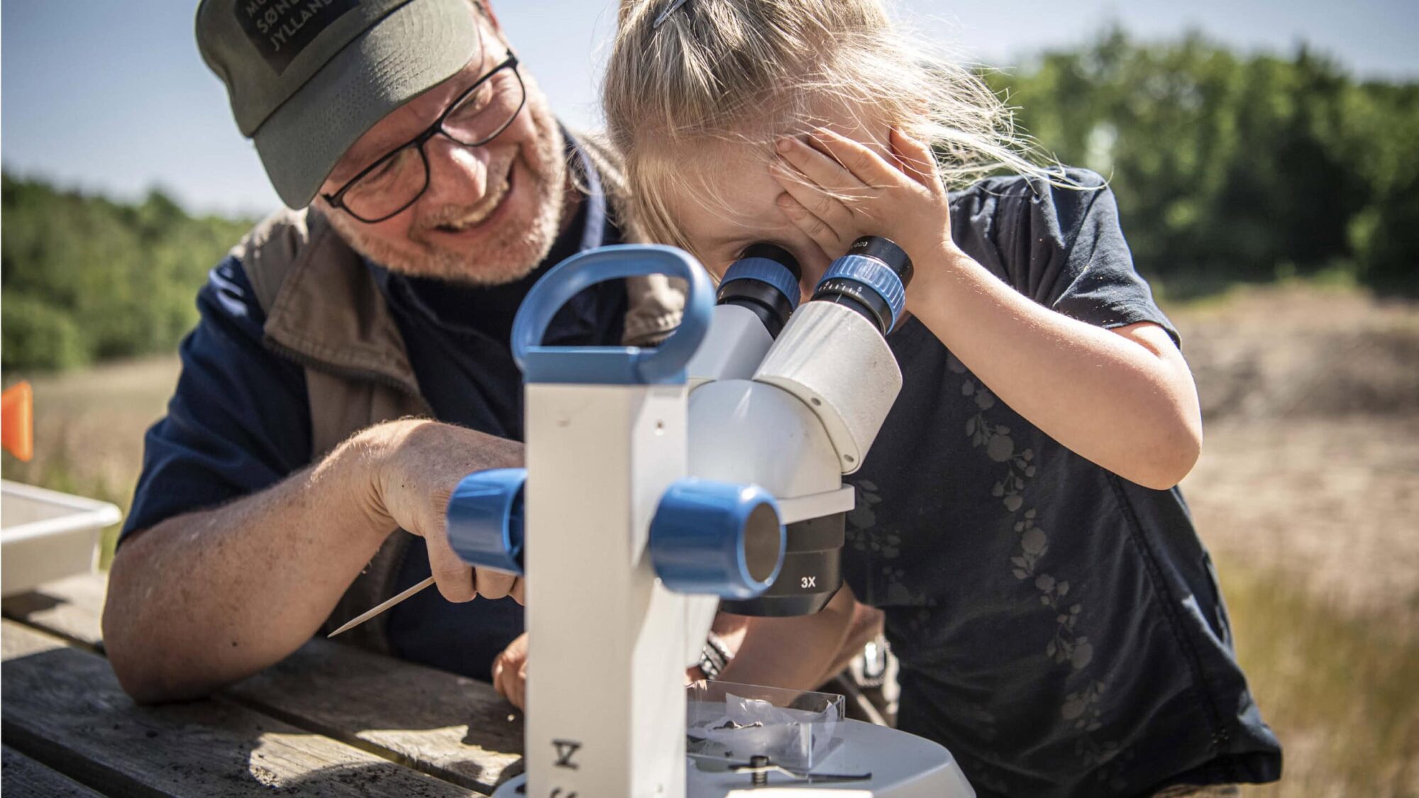 Formidler sider med pige ved et steolup.